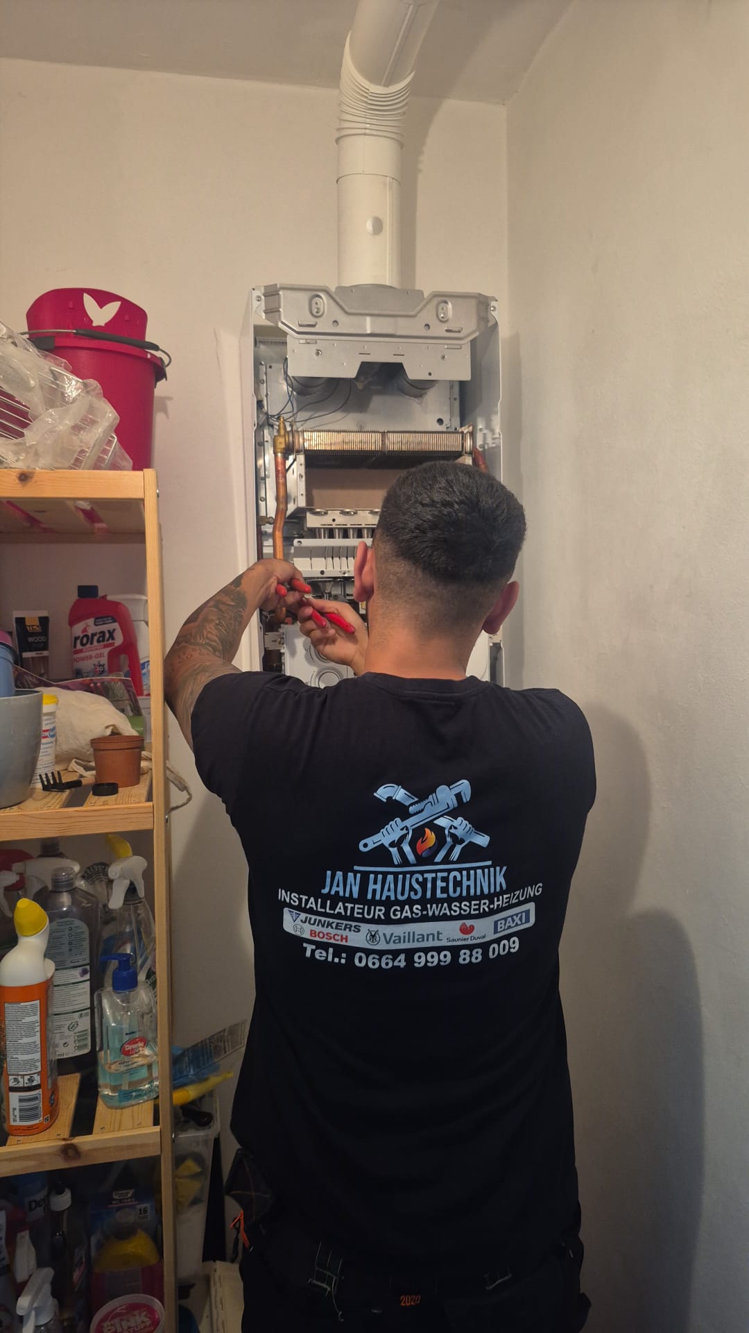 Original JAN Haustechnik Installateur bei Arbeiten an einer geöffneten Therme